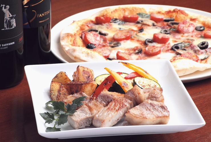 自慢のピザ「サラミとミニトマトのピッツァ」は薄生地タイプでチーズはブッファラを使用