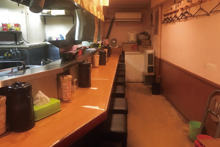 著名人の写真が並ぶ店内は、カウンター9席。食券制での注文